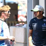 Liam Lawson y Carlos Sainz conversando en el paddock